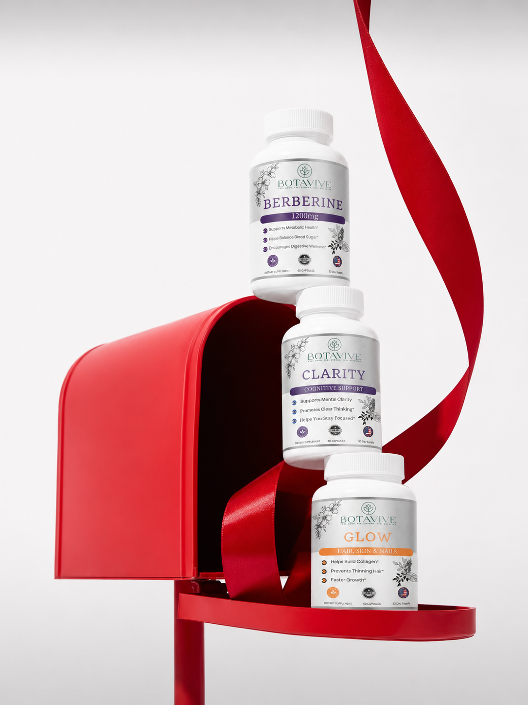 Three bottles of Botanicave supplements stacked inside a red mailbox with a red ribbon.